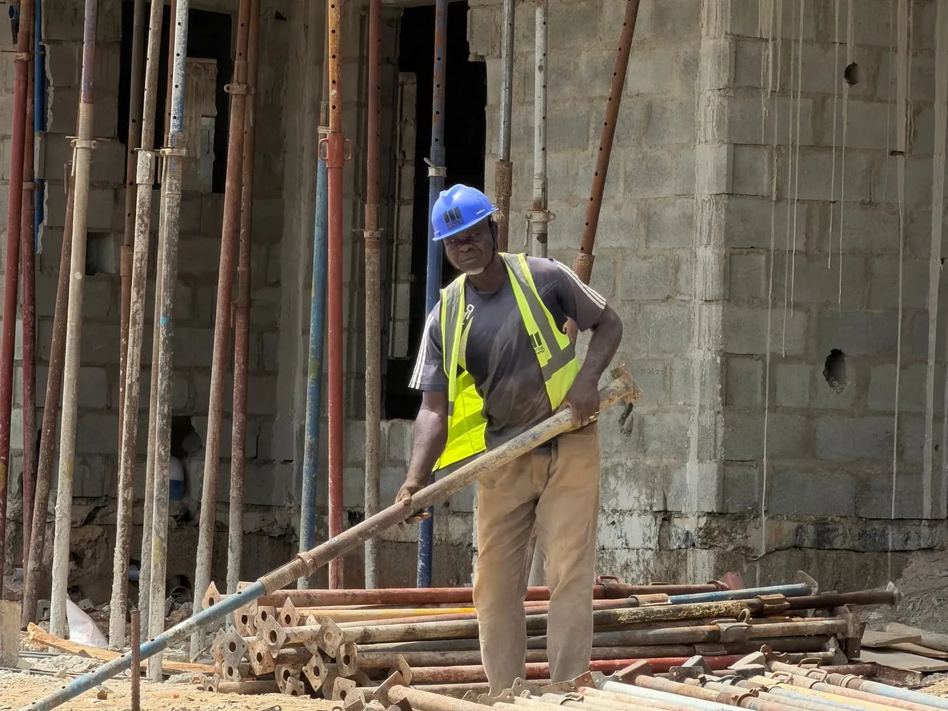 A construction worker in a hard hat and safety vest working at a building site